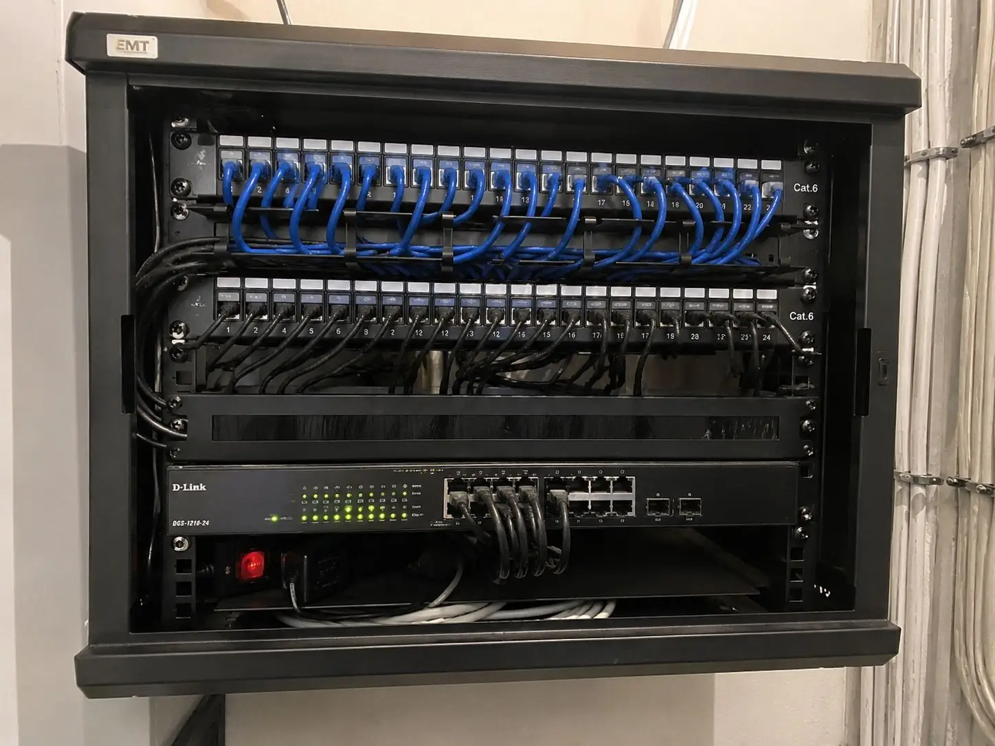 Patchkast met Cat 6 patchpanelen en switch, aangelegd door Electrifusion