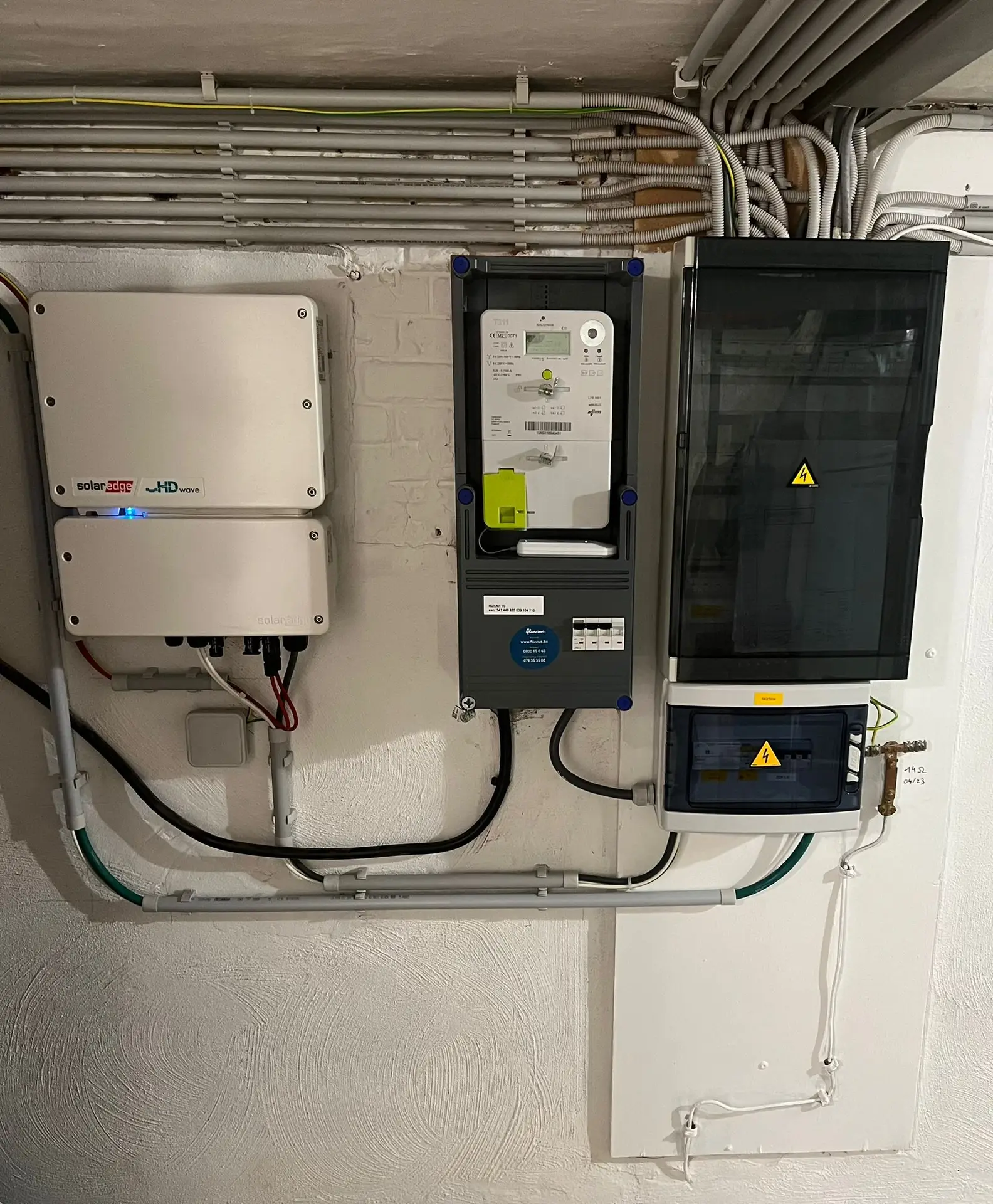 Omvormer naast meterkast en verdeelbord, installatie door Electrifusion